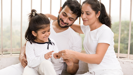 Loving parents sitting with their daughter, engaging in quality bonding time to strengthen family relationships in a supportive home environment.