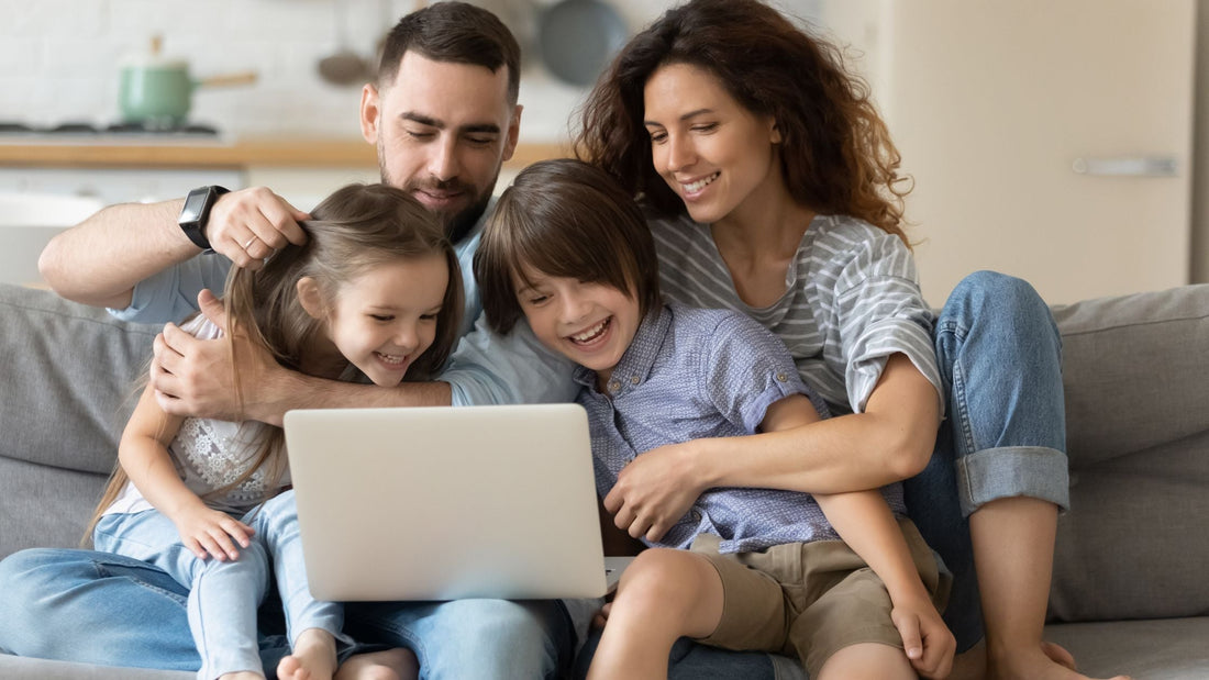 Young parents and children sitting on couch watching educational ADHD video together