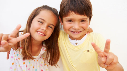 Smiling boy and girl making peace signs, ADHD differences between genders
