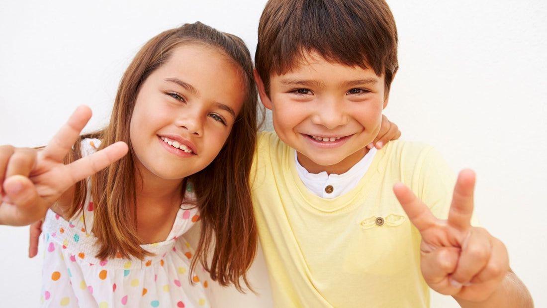 Smiling boy and girl making peace signs, ADHD differences between genders